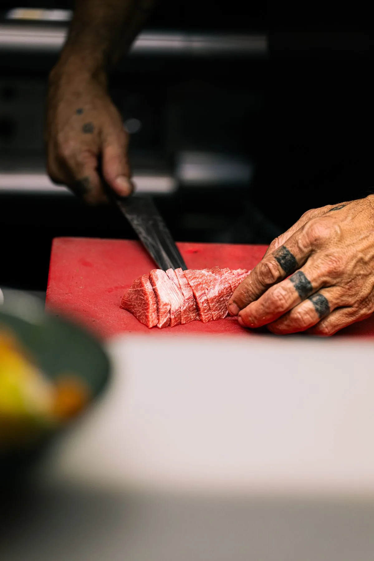 Chef slicing meat with precision on a cutting board