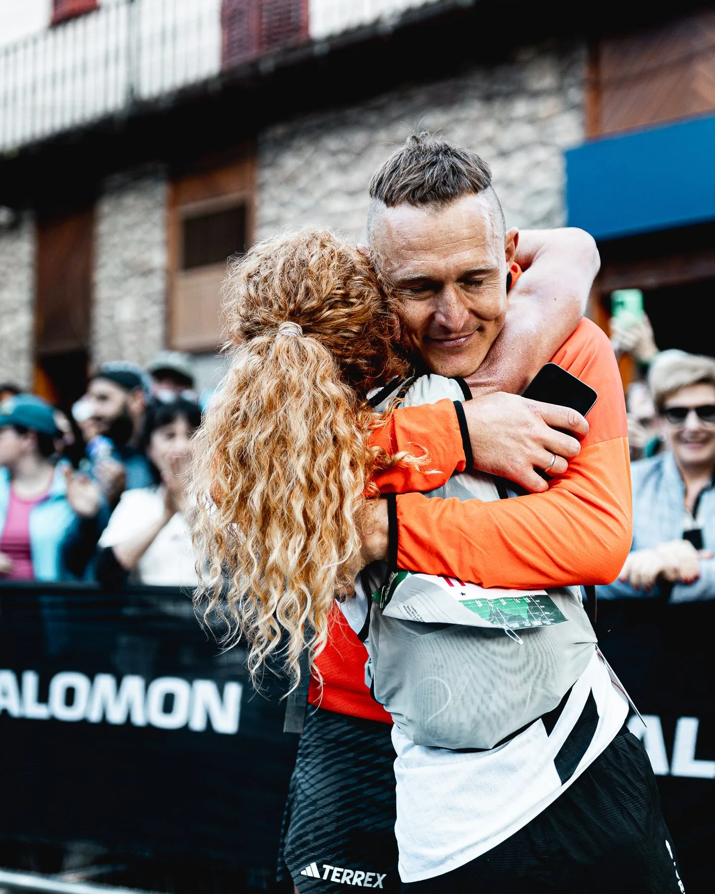Runner embracing a supporter at the finish line