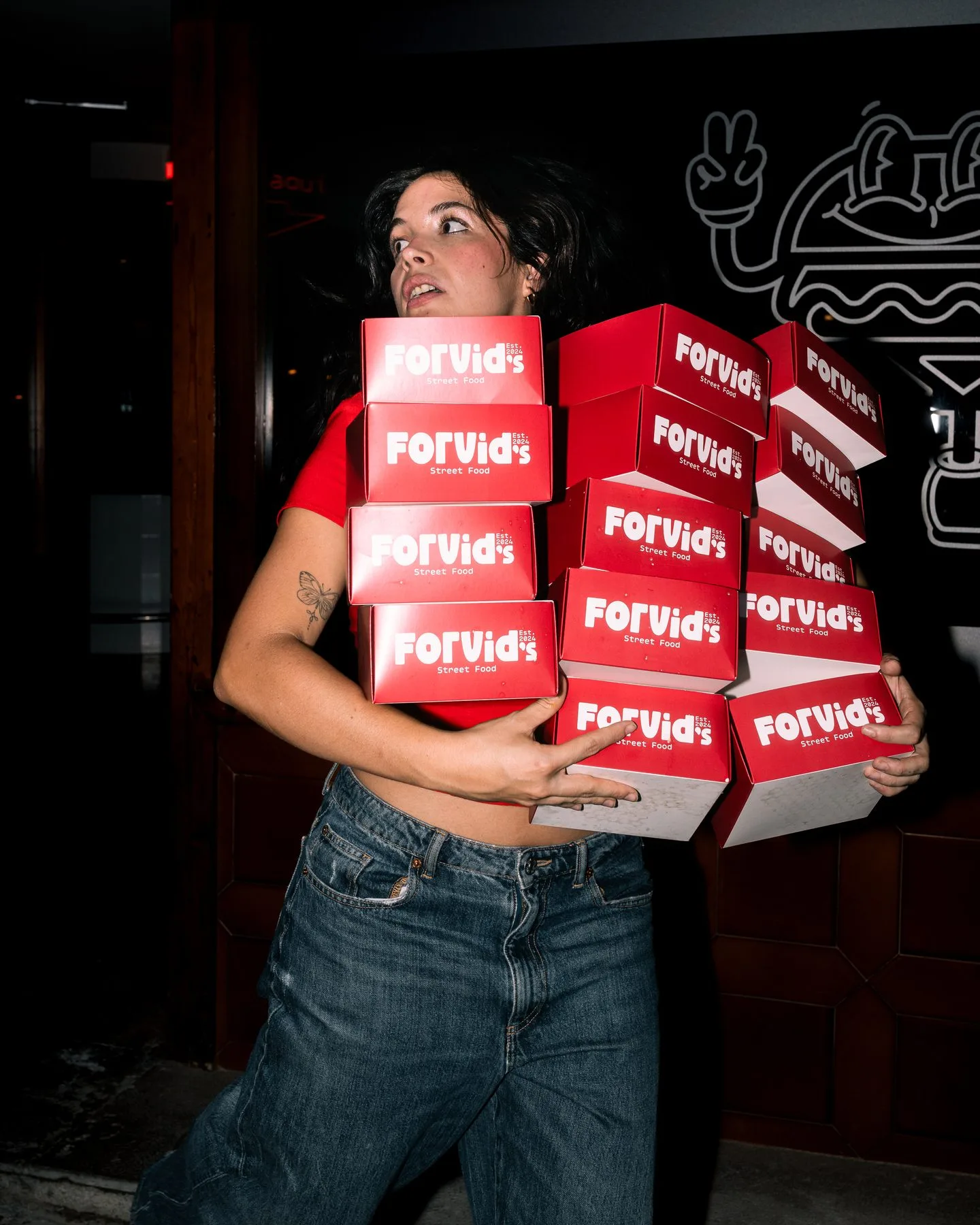 Woman carrying branded food delivery boxes